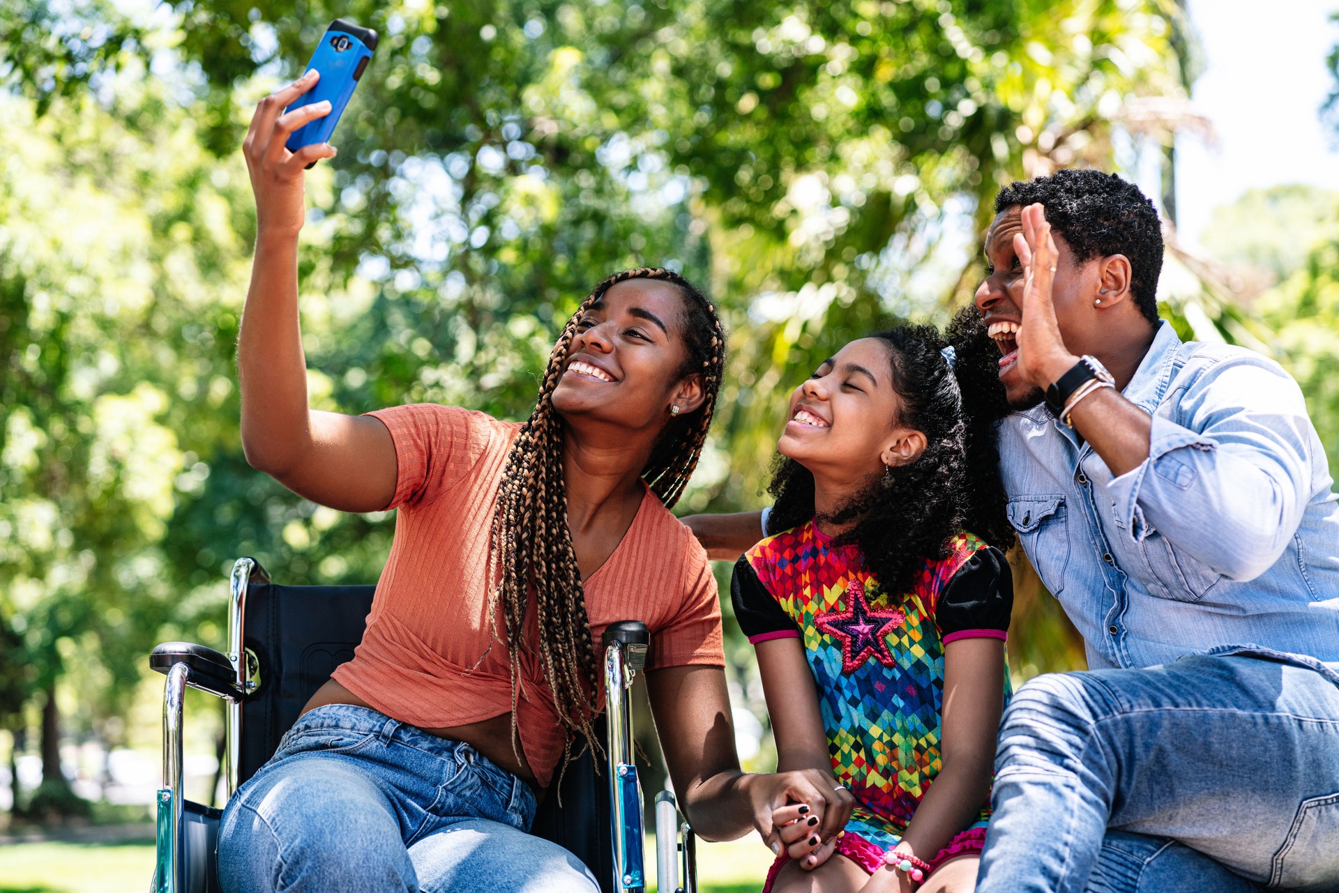 Woman in a wheelchair taking a selfie with her family.