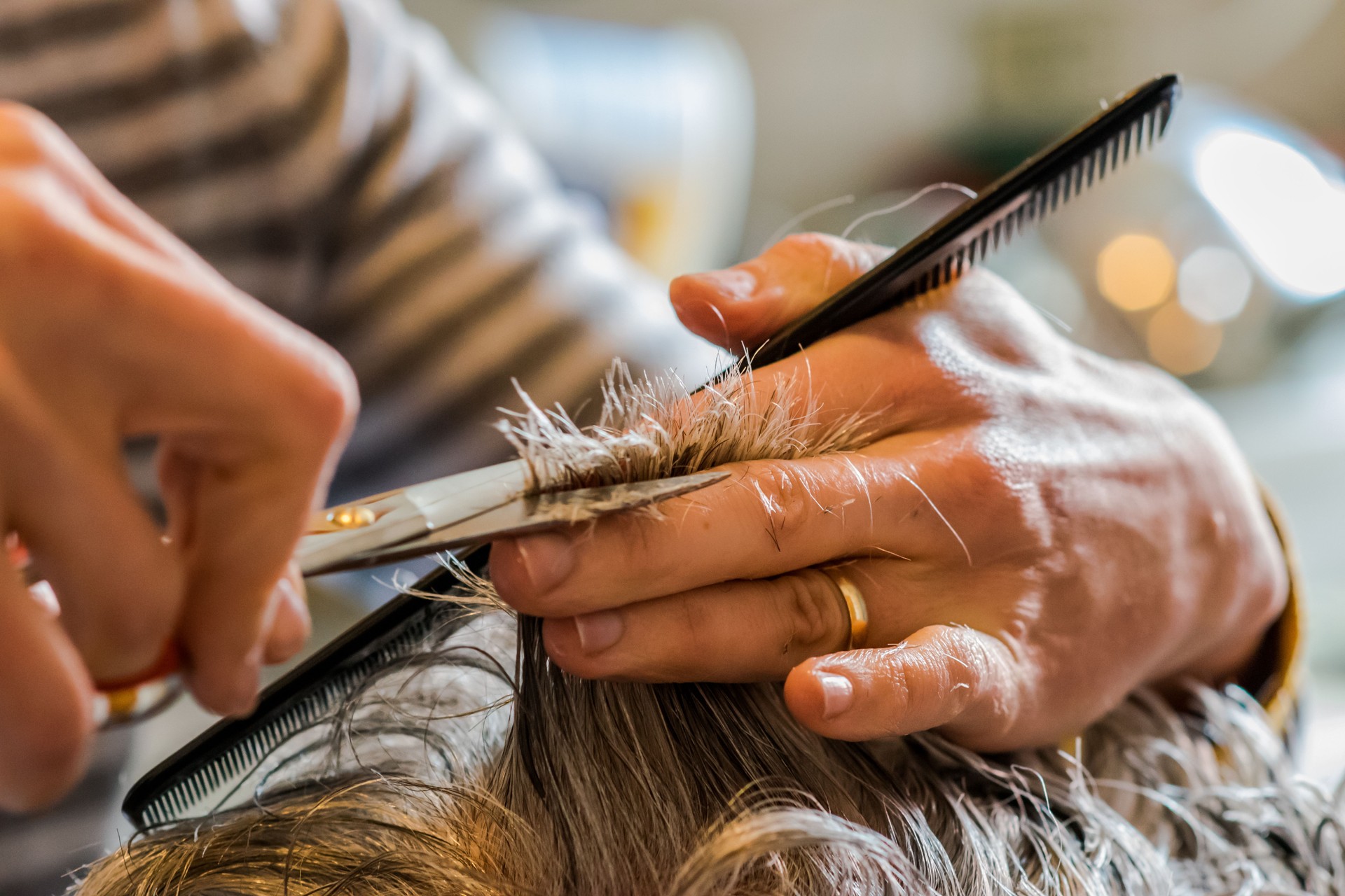 Daughter giving a haircut to her elderly parents